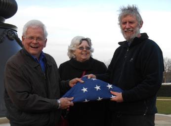 Martin Jones, Sheila Glasswell and Howard Slatter holding the flag, Cambridge American Cemetery, Local History Group visit. Photo: Andrew Roberts, 1 March 2015.