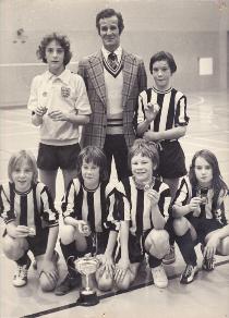 Trumpington Tornadoes with the under-13 cup, January 1976. Standing: Tim Holmes, Neville Haylock (Manager), Andy Caudwell. Front row, left to right: Ken Smith, Gary Haylock, Laurence Cullen and Trudie Mahoney. [Source: Mrs Anna Smith]