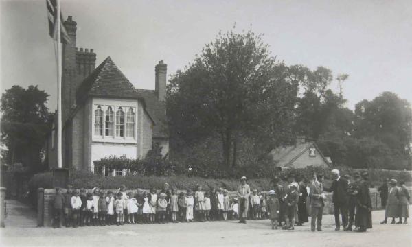 Empire Day, with schoolchildren “Saluting the Flag”, standing to the right of the school in Church Lane. Source: Audrey King, copy photo by Howard Slatter, March 2017.