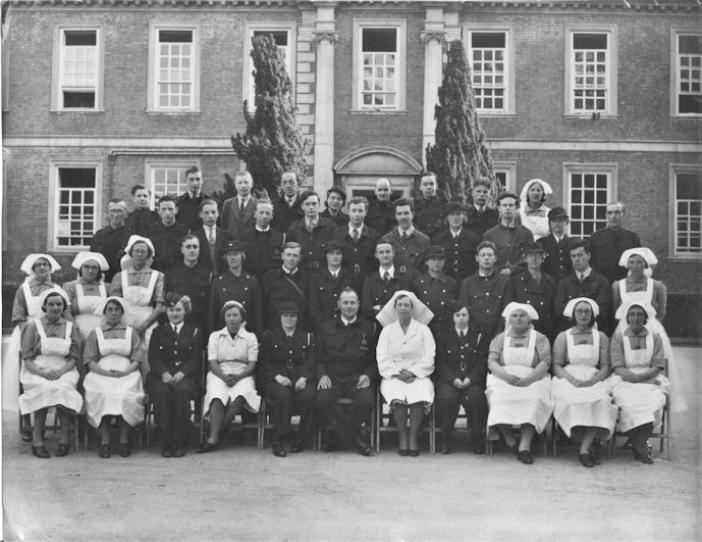 Group of Civil Defence Service men and women in the courtyard in front of the entrance to Anstey Hall, c. 1941. Source: Richard Haynes.