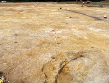Excavating post holes on Clay Farm, Settlement 2, a pattern which influenced the design of the 'Bronze House' artwork in Hobson Square. Oxford Archaeology East, summer 2010.