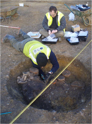 Excavating the Romano-British (Conquest period) cremation burial, north of the path from Paget Close to the Busway, now covered by the Aura development. Oxford Archaeology East, February 2011.