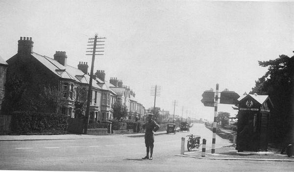Shelford Road from the junction with the High Street and Hauxton Road, 1930s, with houses on the north east side of the road up to and beyond the railway bridge, an AA box at the junction, a line of telegraph poles but no street lights. Cambridgeshire Collection. Reproduced in Trumpington Past & Present, p. 14.