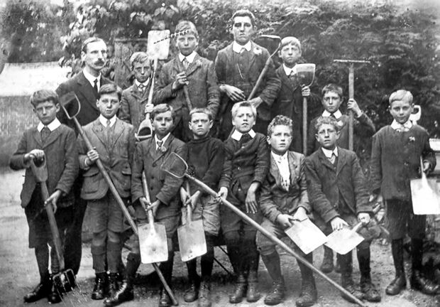 Percy Robinson and pupils from the Church School tending their allotment. Photograph: Cambridgeshire Collection, reproduced in Trumpington Past & Present, p. 45, , and Trumpington in Old Picture Postcards, 23.