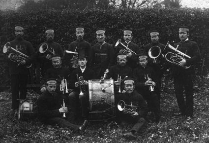 "Trumpington Brass Band in the Eighties" [1880s], 13 members of the Band, dressed in uniforms with caps. The photograph by J.G. Simpson of Huntingdon Road, Cambridge, has been dated to the early 1880s. Percy Robinson collection. It was reproduced with a caption in the Cambridge Chronicle, 21 January 1925, p. 9.