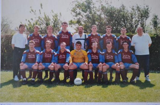Tally Ho Football Club, Trumpington, 1993-1994. Division 4A, Photo: Eaden Lilley. Back row from left: J. Rose (Assistant Manager), P. Ferguson, M. Keefe, R. J. Robinson, T. Tinkler (Chairman), S. Rose, Konrad Bidwell, Karl Cockerton, Martin Brown (Manager). Front row from left: J. Goodwin, S. G. Bates, Peter J. Huckle, M. J. Pearl (Captain), Stephen Thompson, Brenden Powter, J. Rose ‘Junior’. Absent: D. Lancaster. Source: photograph loaned by Stephen Thompson.