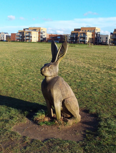 Replacement carving of a hare on the Country Park meadow (slightly smaller and different pose). Photo: Randall Evans, February 2024.