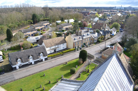 Looking from Trumpington church tower along the nave roof and north along Grantchester Road, with Addenbrooke’s Hospital. Photo: Andrew Roberts, 7 April 2012.