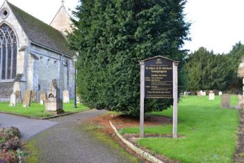 The north east entrance to the churchyard, with the information panel with the Pendlebury memorial on the reverse, the line of Nichols family headstones to the left and the Saunders and Reeves headstone to the right (entry 1, 3 and 2). Photo: Andrew Roberts, 27 October 2013.