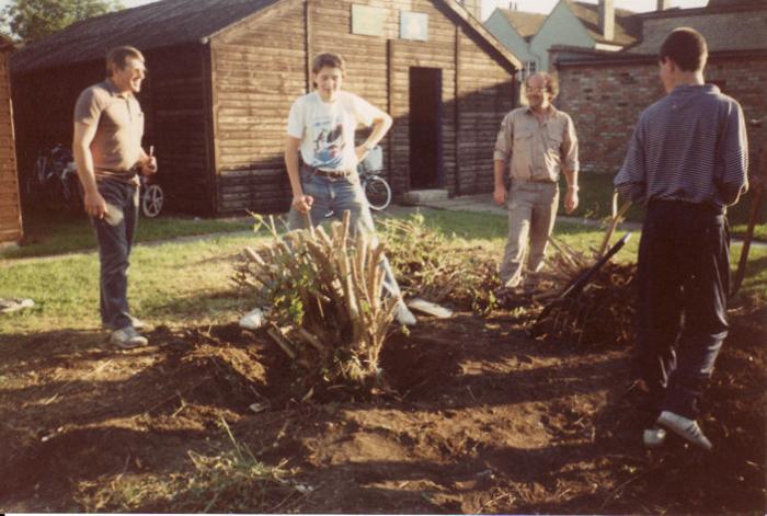 A working party of Scout leaders and parents, including Ian Truelove, clearing scrub and weeds from in front of the huts, 1980s.