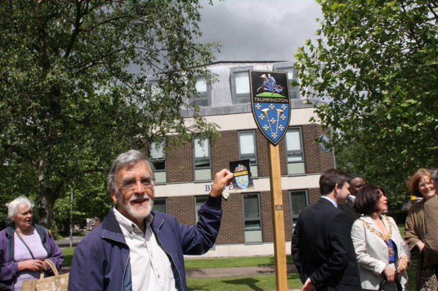 Peter Dawson holding a photograph of the original Village Sign alongside the new sign, 15 June 2010. Photo: Martin Jones.